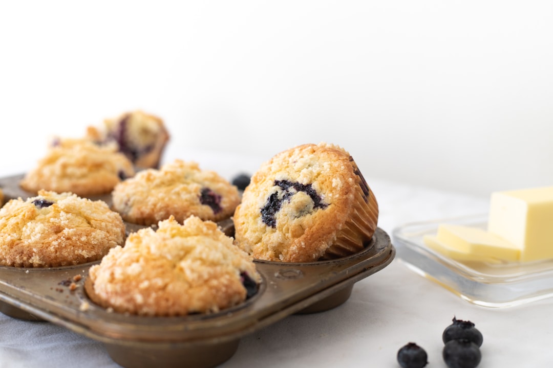 blueberry-muffins-in-a-muffin-tin-with-butter-on-the-side-qxh53pfyxhw